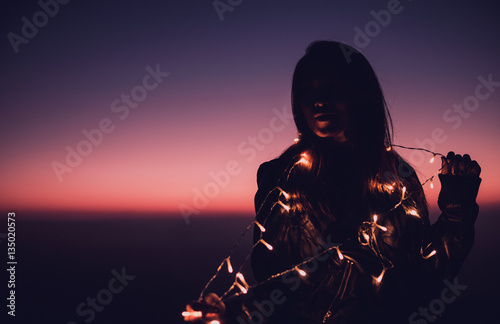 woman with decorate light in colorful twilight
