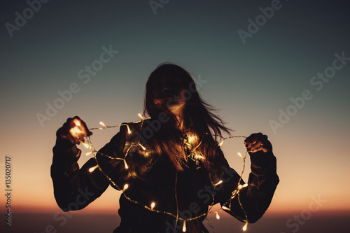 woman with decorate light in colorful twilight