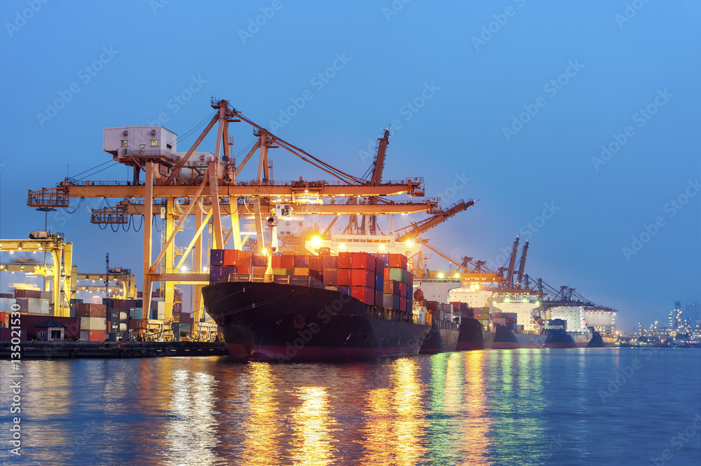 Containers loading by big crane at dark sunset, Shipping Trade Port in Thailand
