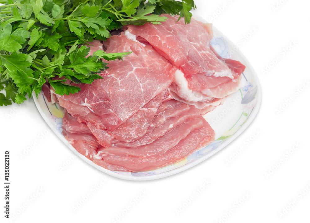 Sliced uncooked pork on dish against the background of parsley Sliced uncooked pork on dish against the background of parsley