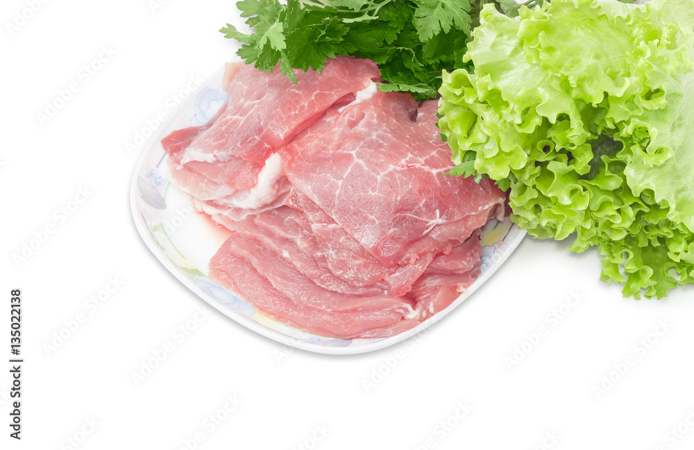 Sliced uncooked pork on dish on background of parsley and lettuce Sliced uncooked pork on dish on background of parsley and lettuce