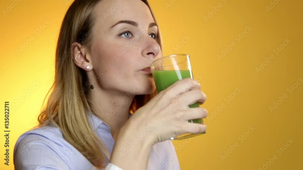 Young woman drinking green vegetable smoothie Young woman drinking green vegetable smoothie