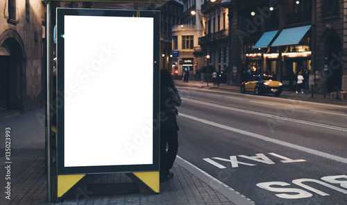 Blank advertising light box on bus stop, mockup of empty ad billboard on night bus station, template banner on background city street for poster or sign, afisha board and headlights of taxi cars. photo
