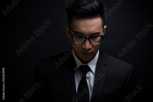 Businessman in black suit on isolated black background