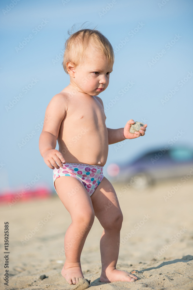 Baby playing with toys on the sandy beach near the sea. Cute little kid in sand on tropical beach. Ocean coast. Baby playing with toys on the sandy beach near the sea. Cute little kid in sand on tropical beach. Ocean coast.