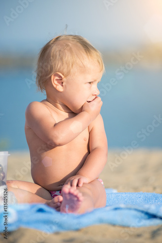 Baby playing with toys on the sandy beach near the sea. Cute little kid in  sand on tropical beach. Ocean coast. © mr.markin
