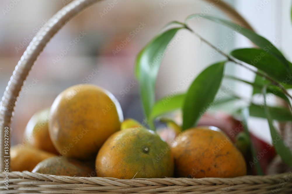 Fresh oranges group and nature green leaves in basket blur background