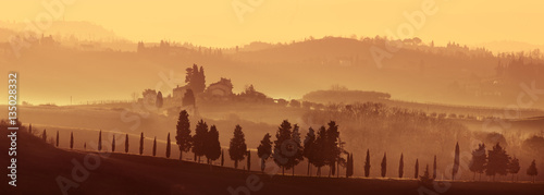 Typical landscape of Tuscany on a foggy sunset, Italy photo