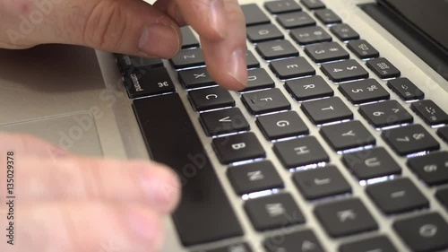Male hands typing copy and paste keys combintaio on a laptop keyboard. Side view