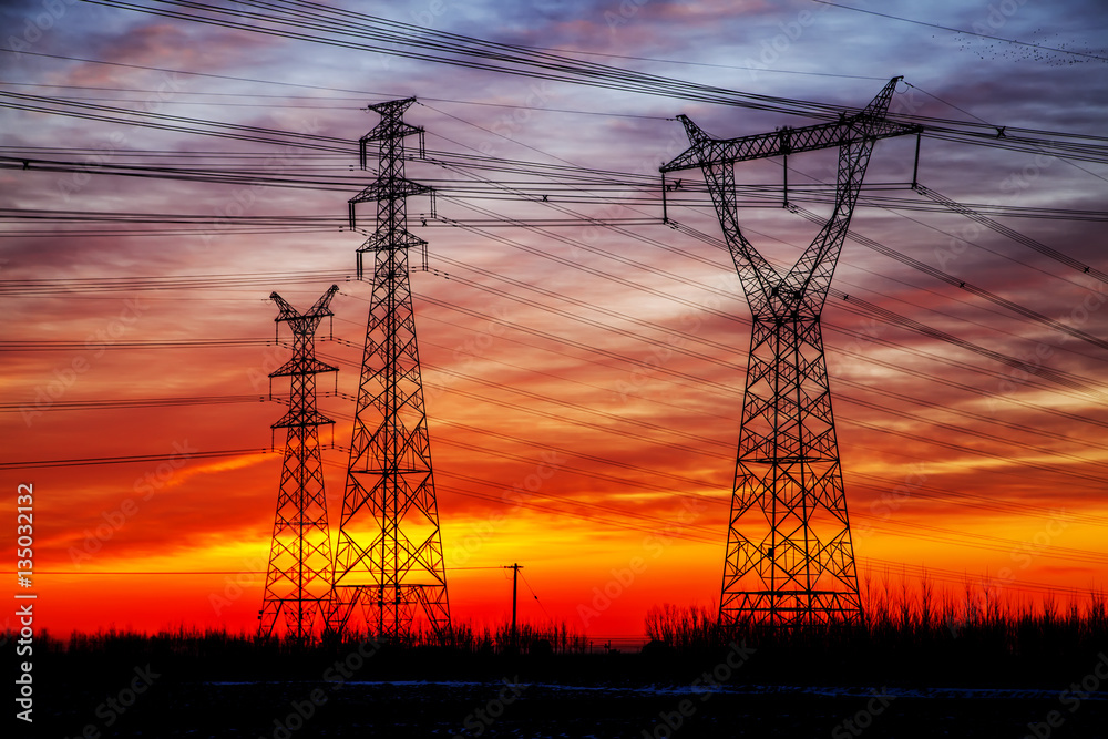 The silhouette of the evening electricity transmission pylon