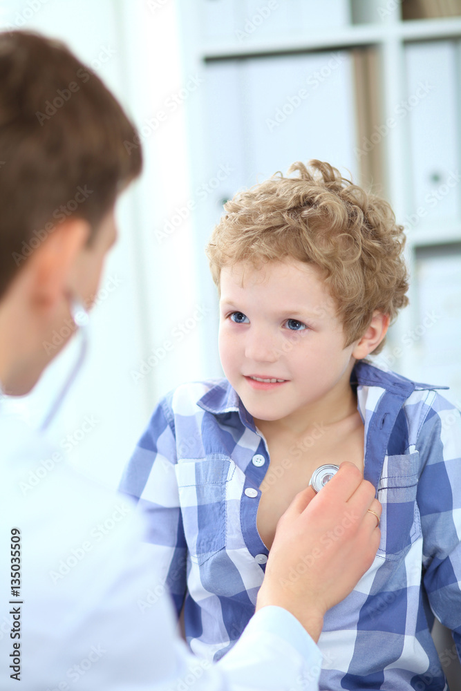 Male doctor auscultating a little boy by stethoscope. Health care, insurance and help concept. Male doctor auscultating a little boy by stethoscope. Health care, insurance and help concept.