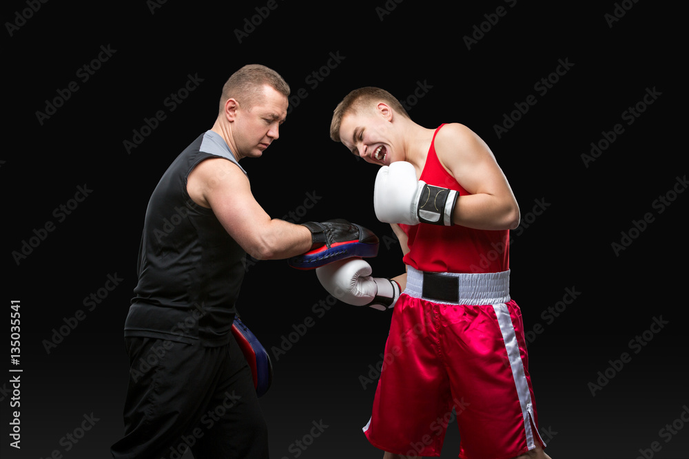 Young boxer working out with coach Young boxer working out with coach