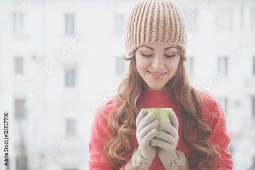 beautiful girl in a hat and gloves, drinking hot tea