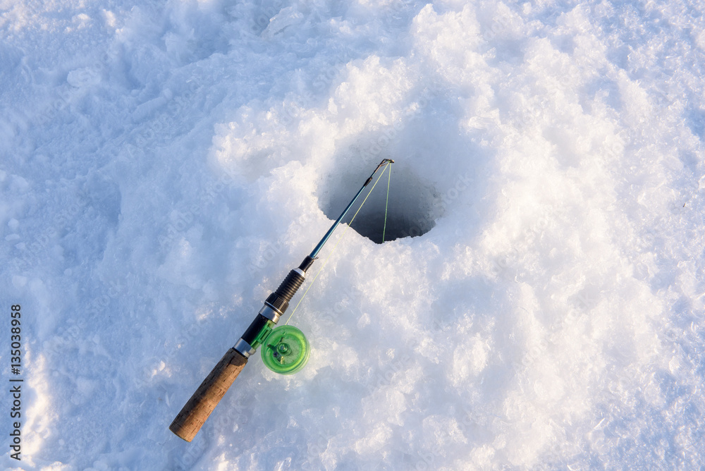 Winter fishing rod lies approximately drilled holes. Winter fishing on the lake. Winter fishing rod lies approximately drilled holes. Winter fishing on the lake.