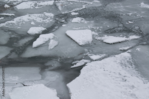 Frozen river with accumulated drift ice putting preasure on dock photo