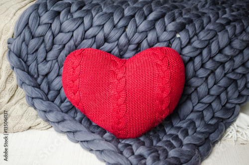 Knit red heart on knitted plaid