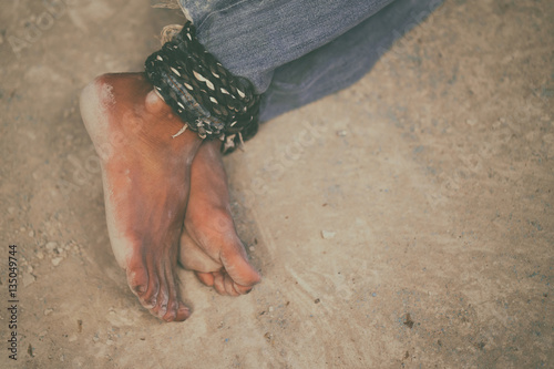 hopeless man feet tied together with rope photo