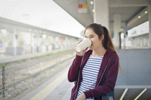 Teenager drinking hot coffee at the station