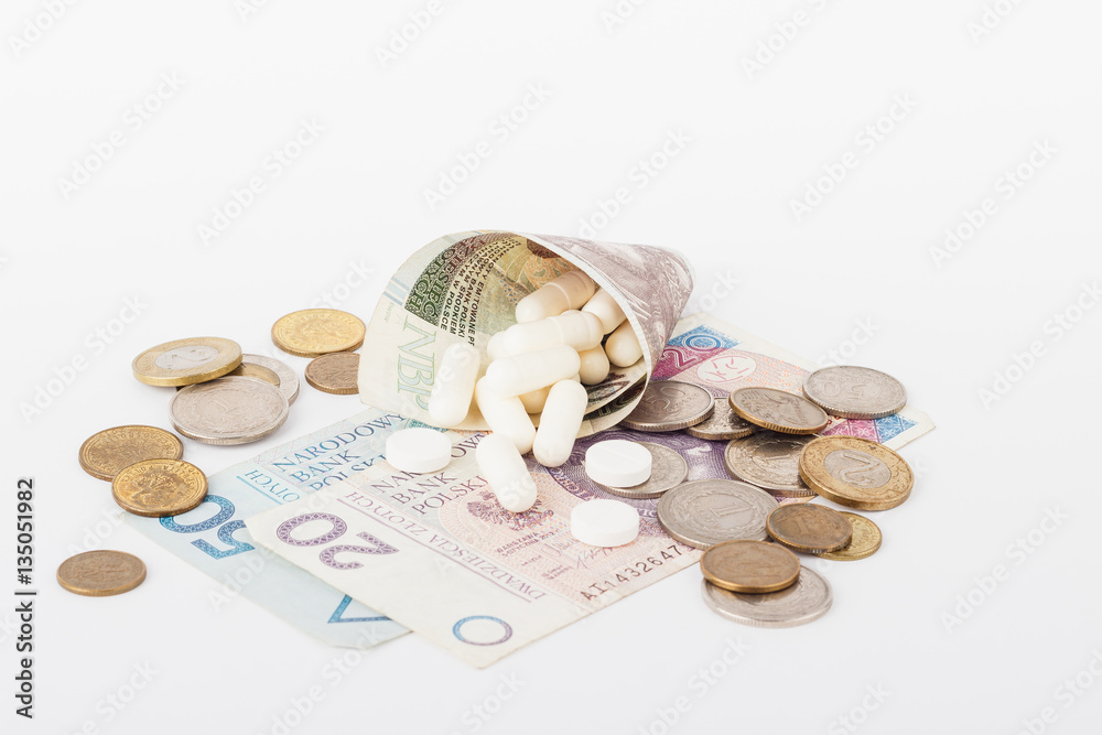 Conceptual image: Polish zloty and a little pills on the light background Conceptual image: Polish zloty and a little pills on the light background