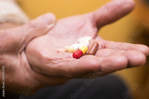 Senior man with pill in hand