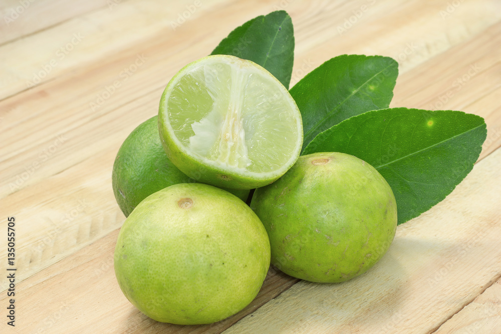 Fresh lime fruit sour taste with a half on wood background. Fresh lime fruit sour taste with a half on wood background.