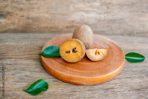 fresh sapodilla fruits on old wooden background photo