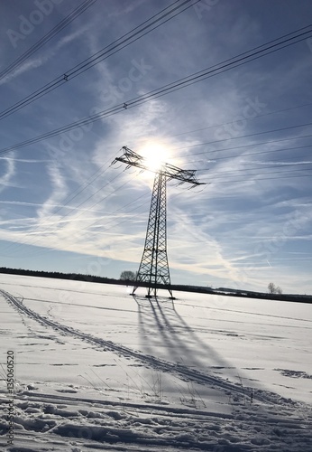 Winterlandschaft mit Schnee bei strahlendem Sonnenschein - Strommast mit Loipe