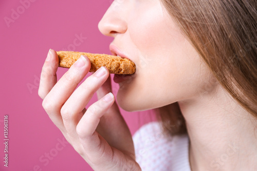 Young woman with cookie on ...