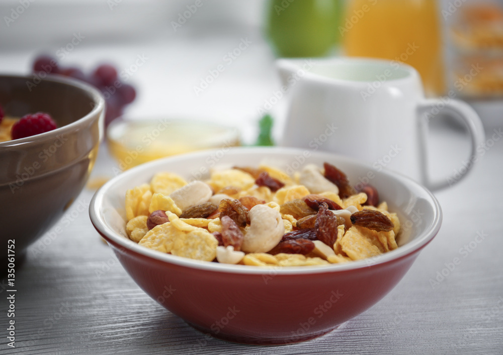 Tasty cornflakes with raisins and nuts and honey on table Tasty cornflakes with raisins and nuts and honey on table