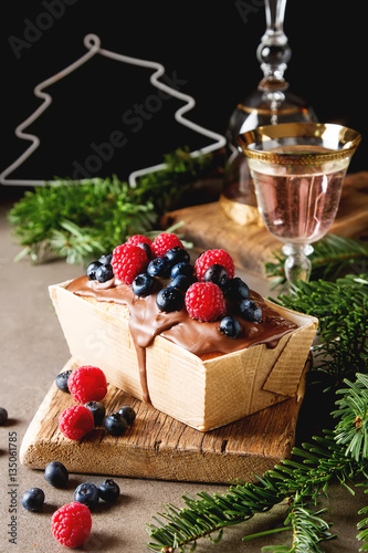 Christmas cake with chocolate frosting, blueberries and raspberr photo