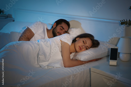 Young cute couple sleeping together in bed