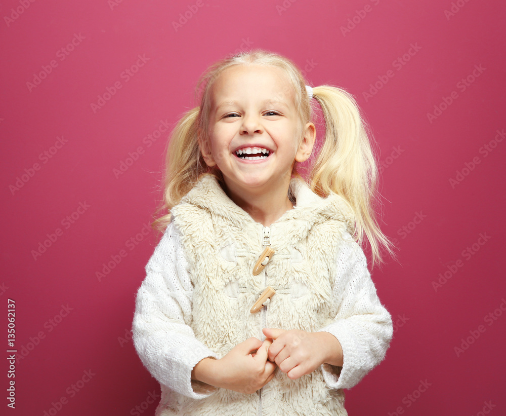 Funny little girl in warm clothes on color background Funny little girl in warm clothes on color background