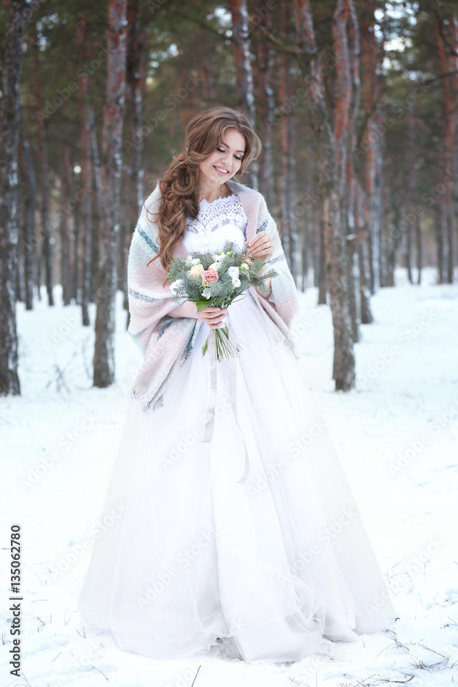 Beautiful bride with bouquet outdoors on winter day