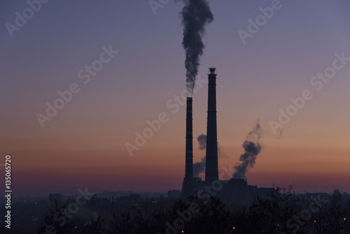 Thermal power plant on the sunset background