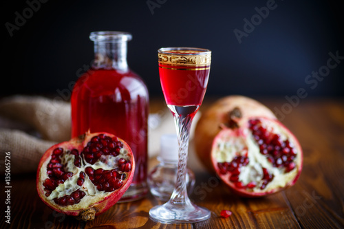 sweet pomegranate alcoholic cordial in the decanter with a glass