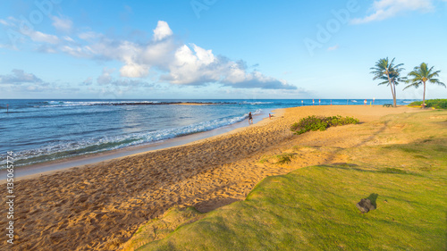 A man and his son playing at Poipu beach, Kauai island, Hawaii photo