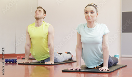 Young people on exercises mat in gym