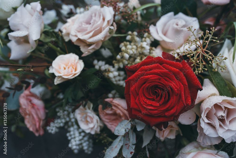 Fototapeta premium Wedding decorations. Bouquet of white and red flowers on a table with candles. Close-up.