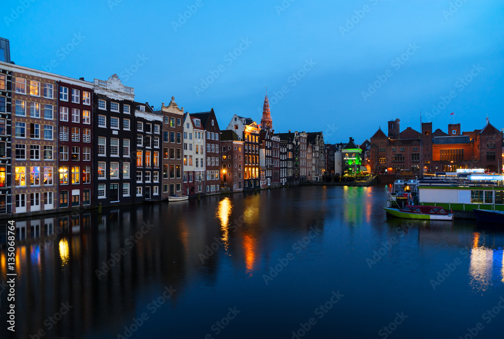Houses over canal with mirror reflections at blue night, Amstardam, Netherlands