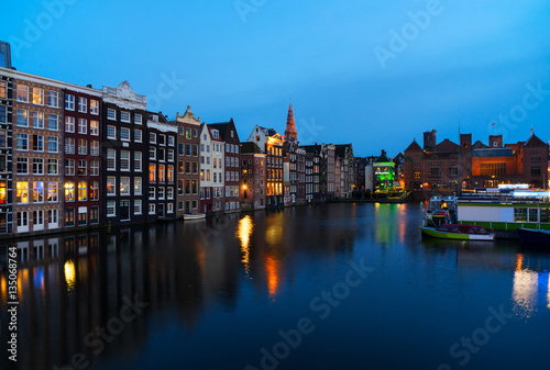 Houses over canal with mirror reflections at blue night, Amstardam, Netherlands