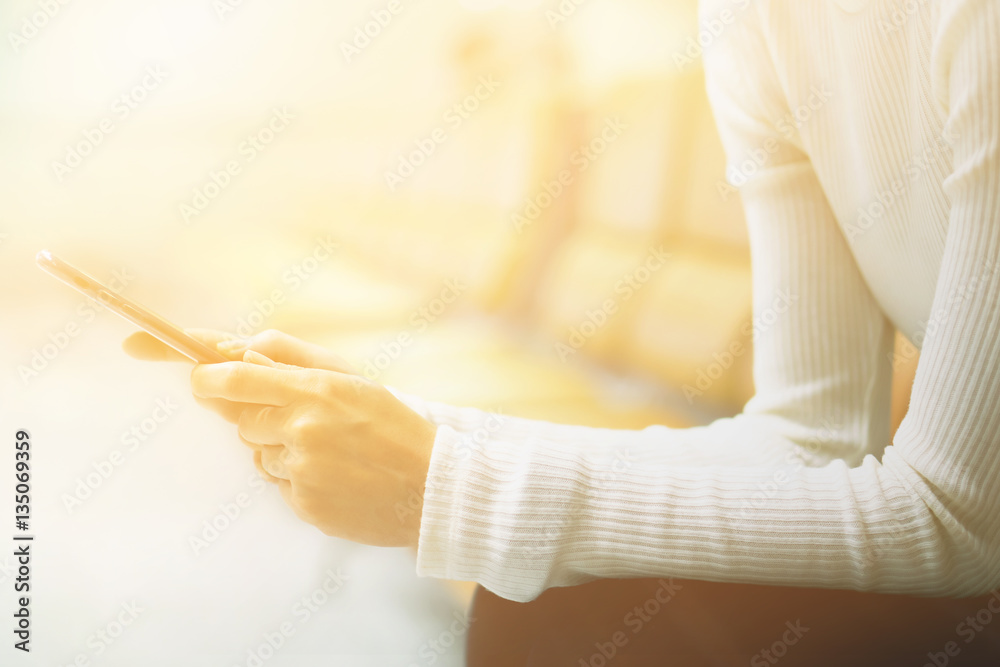 Obraz premium Woman at airport texting on a smartphone