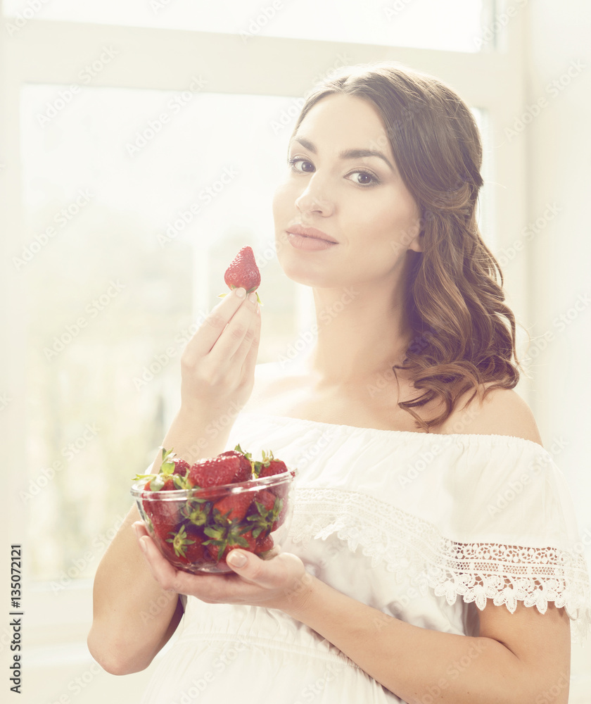 Beautiful and young girl eating strawberries Beautiful and young girl eating strawberries