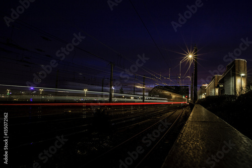 Befahrene Bahnlinie über die Hohenzollernbrücke in Köln bei Nacht