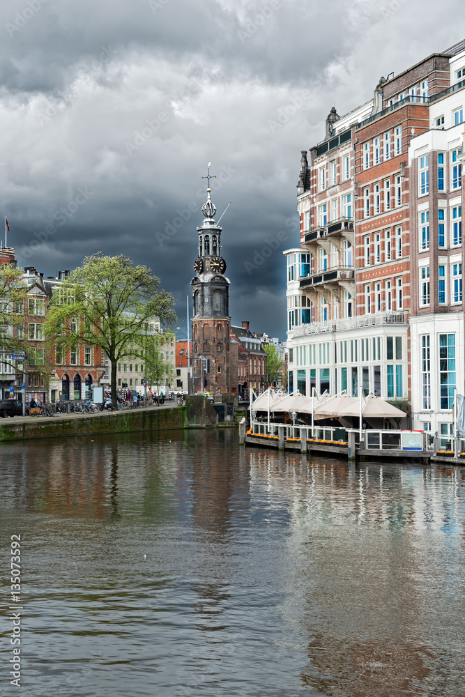 center of Amsterdam with Munt tower with dramatic sky, Netherlands