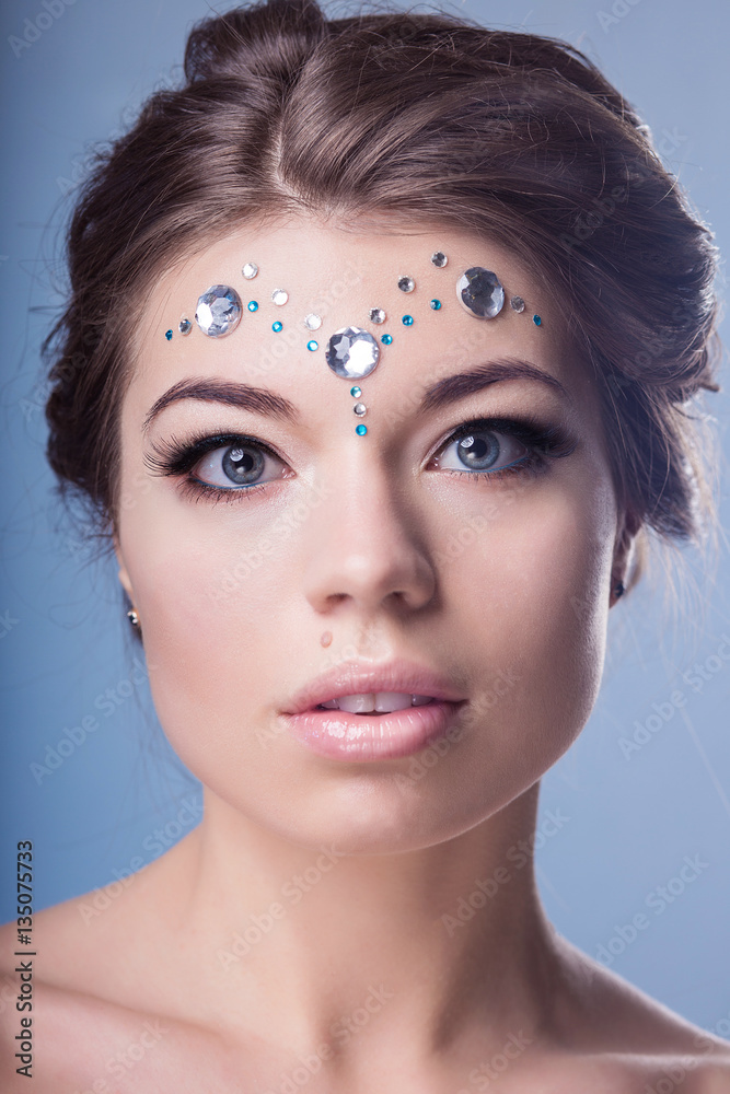 Fototapeta premium compelling woman with makeup and sequins on her face