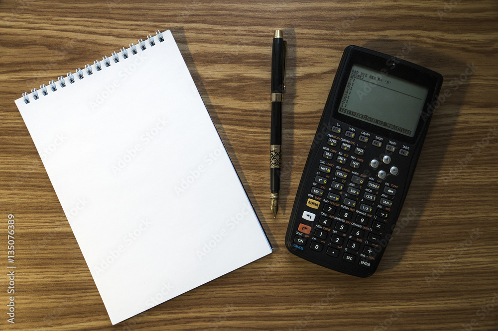 Notepad, fountain pen and calculator on wooden background Notepad, fountain pen and calculator on wooden background
