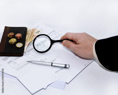 Man writes a pen on an tax document.