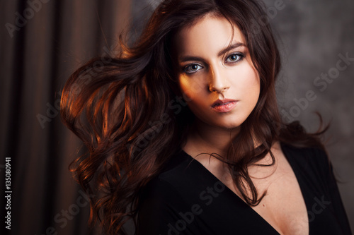 Delightful portrait of a woman brunettes, hair flying on the wind, sloppy styling