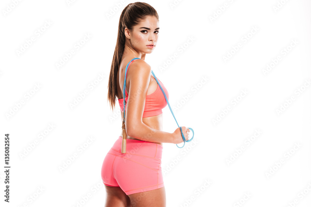 Young beautiful sports woman standing and holding skipping rope Young beautiful sports woman standing and holding skipping rope
