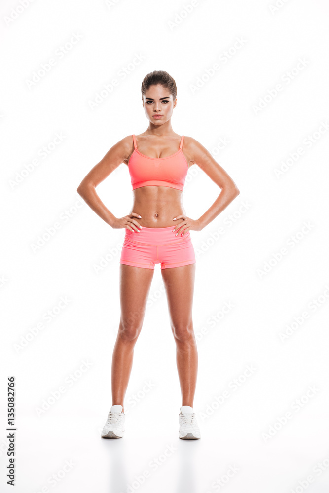 Beautiful sexy sportswoman standing with hands on hips Beautiful sexy sportswoman standing with hands on hips